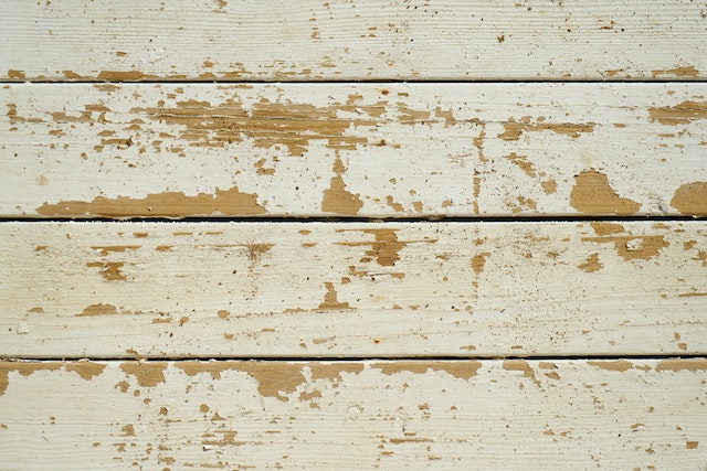 white paint chipping off a wooden wall