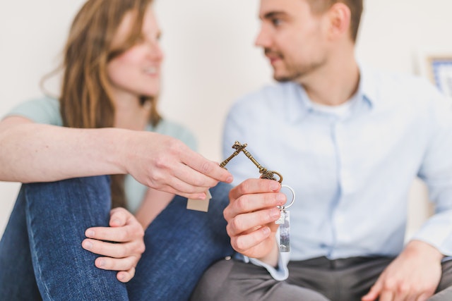 two tenants cheers-ing with housing keys to signify moving into a new place