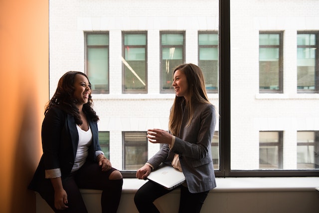 two people having a conversation next to a window