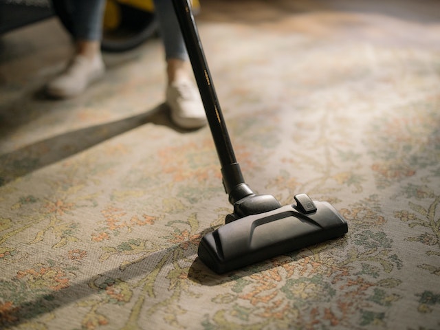 someone vacuuming a rug