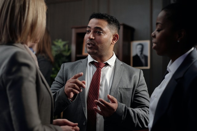 three people in suits having a conversation