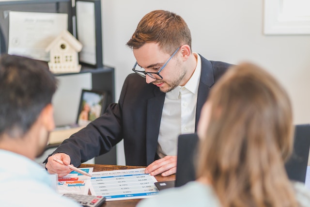 a professional showing two people a chart