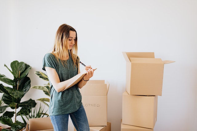 someone taking notes in front of moving boxes